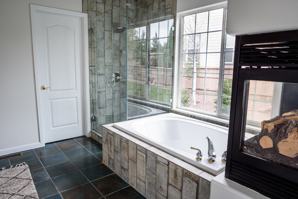 Example of a large transitional master gray tile and glass tile concrete floor drop-in bathtub design in Denver with white walls