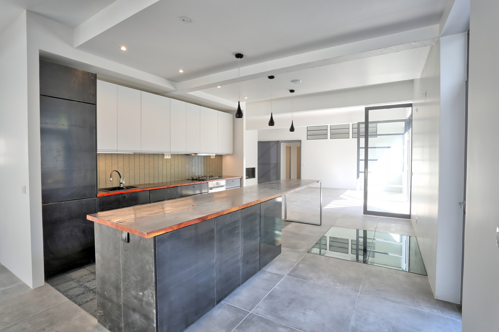 This is an example of a large contemporary galley open plan kitchen in Paris with an undermount sink, flat-panel cabinets, black cabinets, wood benchtops, beige splashback, mosaic tile splashback, ceramic floors, with island, grey floor, stainless steel appliances and red benchtop.