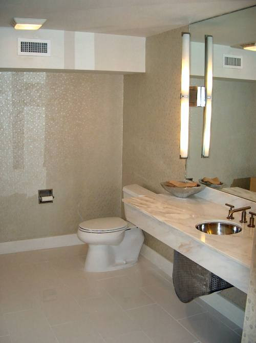 Inspiration for a mid-sized contemporary 3/4 bathroom in New Orleans with open cabinets, white cabinets, a two-piece toilet, mirror tile, red walls, porcelain floors, an undermount sink, marble benchtops and white floor.