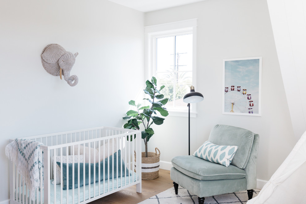 Design ideas for a country gender-neutral nursery in Los Angeles with grey walls, medium hardwood floors and brown floor.