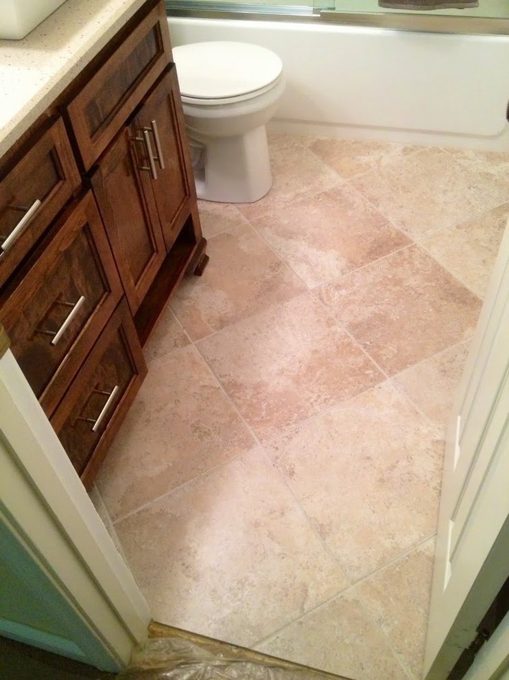 Mid-sized minimalist beige tile and ceramic tile ceramic tile home design photo in New Orleans with shaker cabinets, medium tone wood cabinets, a one-piece toilet, green walls, a vessel sink and granite countertops