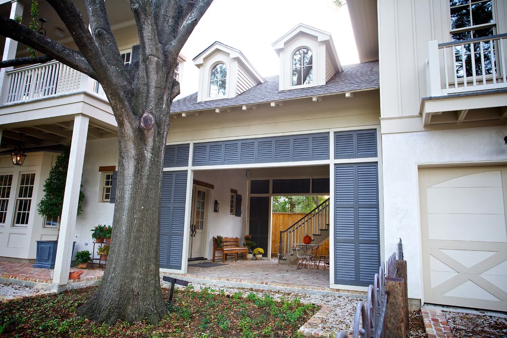 Inspiration for an expansive traditional two-storey stucco grey house exterior in Houston with a shingle roof, a grey roof and board and batten siding.