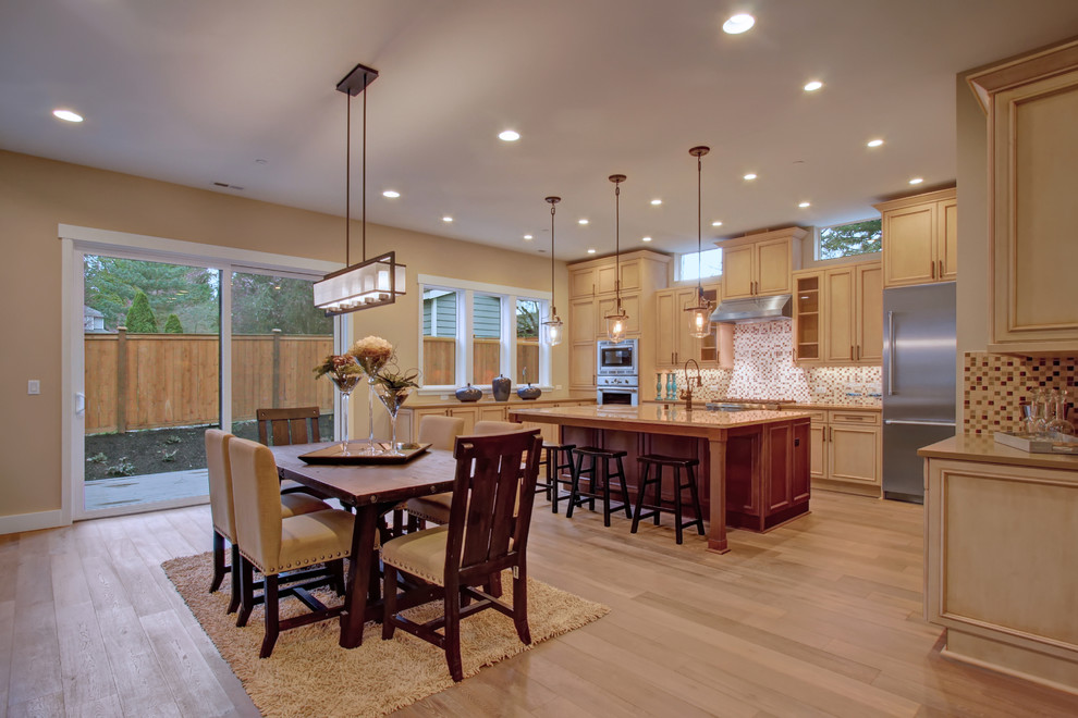 Design ideas for a traditional u-shaped eat-in kitchen in Seattle with beaded inset cabinets, light wood cabinets, quartz benchtops, multi-coloured splashback, mosaic tile splashback, stainless steel appliances, medium hardwood floors and with island.