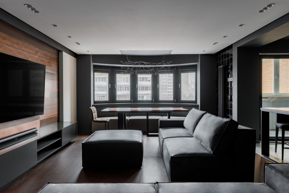 Стильный дизайн: открытая, серо-белая гостиная комната среднего размера в современном стиле с домашним баром, серыми стенами, полом из керамогранита, телевизором на стене, коричневым полом, многоуровневым потолком, панелями на стенах и эркером - последний тренд
