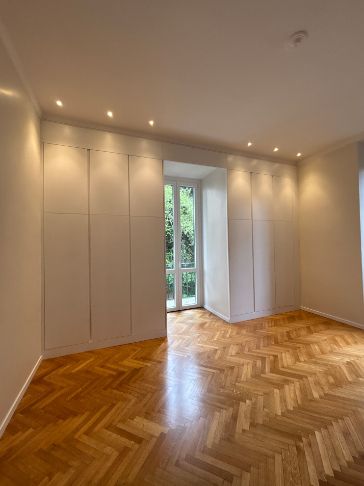Esempio di una piccola camera matrimoniale chic con pareti beige, parquet chiaro, pavimento marrone, soffitto ribassato e carta da parati