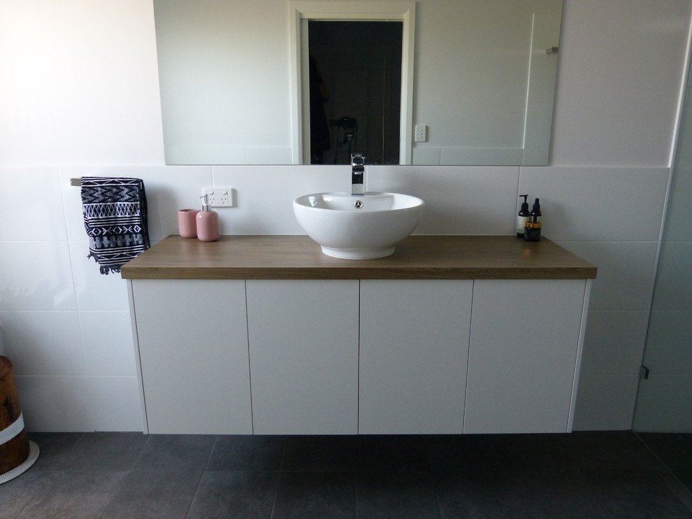 Mid-sized contemporary master bathroom in Adelaide with flat-panel cabinets, white cabinets, white tile, porcelain tile, white walls, cement tiles, laminate benchtops, grey floor and brown benchtops.