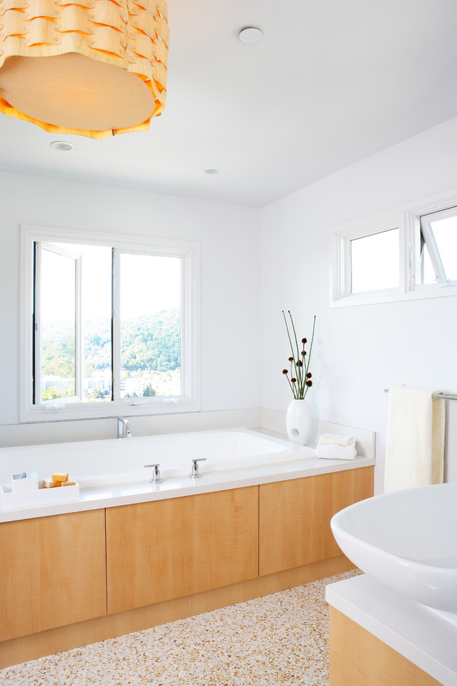 Photo of a midcentury bathroom in San Francisco with a vessel sink, light wood cabinets, an alcove tub and white walls.