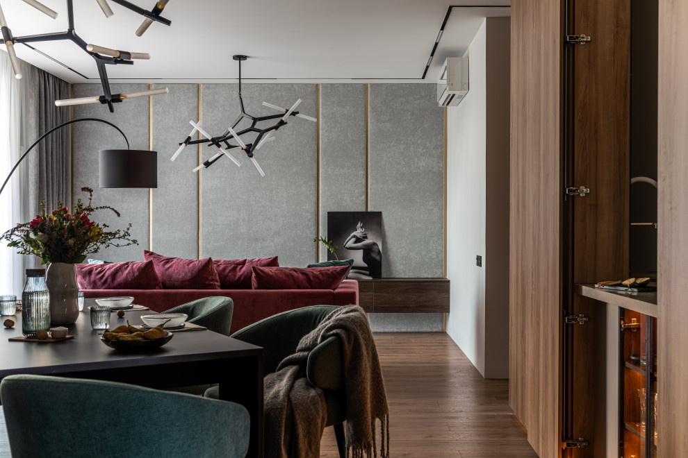 Идея дизайна: гостиная комната среднего размера в современном стиле с серыми стенами, полом из ламината, зоной отдыха, коричневым полом, обоями на стенах и бордовым диваном