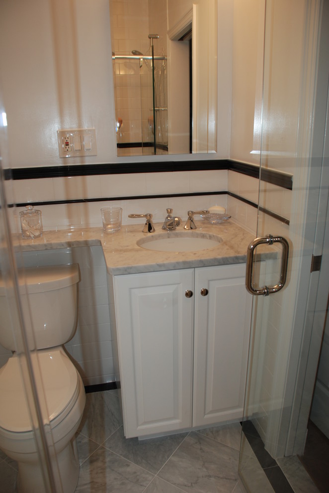 Small traditional 3/4 bathroom in DC Metro with raised-panel cabinets, white cabinets, an alcove shower, a two-piece toilet, black tile, black and white tile, white tile, subway tile, white walls, porcelain floors, an undermount sink and marble benchtops.