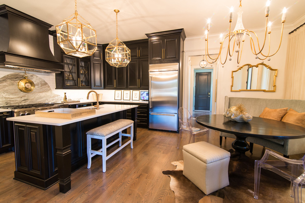 Design ideas for a mid-sized traditional l-shaped eat-in kitchen in Atlanta with an undermount sink, raised-panel cabinets, black cabinets, marble benchtops, white splashback, ceramic splashback, stainless steel appliances, medium hardwood floors and with island.
