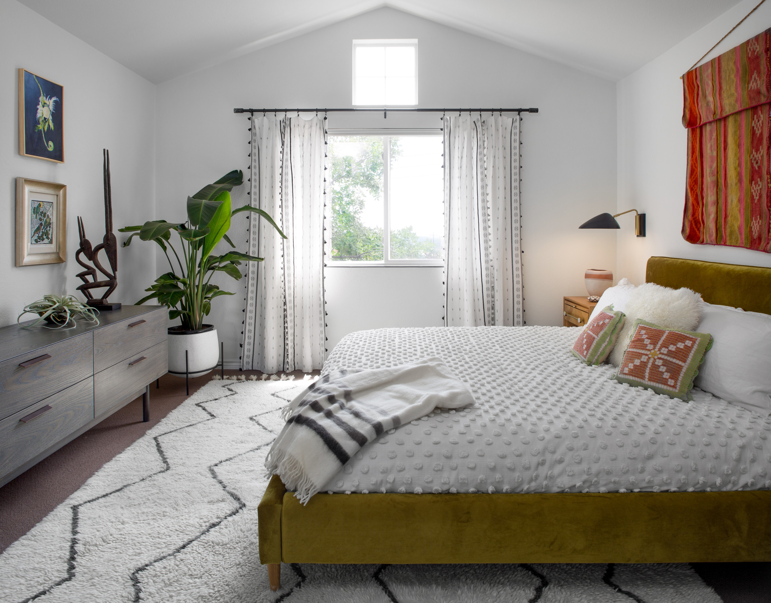 Ah, the bedroom! With our tight budget, we opted to keep the original berber carpet and add an area rug. We ordered the chartreuse velvet bed from Interior Define. The coverlet is from Urban Outfitter