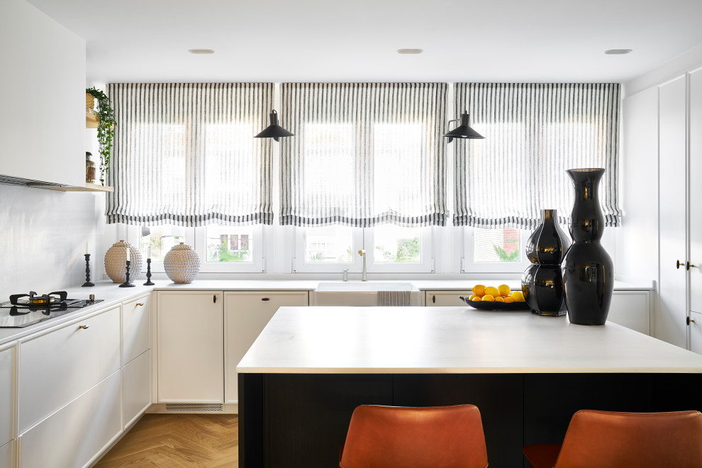 Design ideas for a world-inspired u-shaped kitchen in Bilbao with white cabinets, marble worktops, white splashback, marble splashback, light hardwood flooring, an island and white worktops.