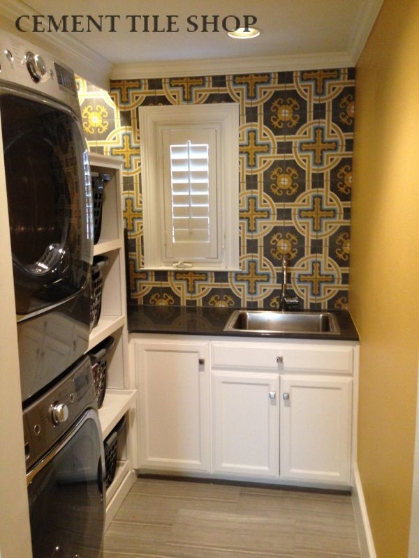 Inspiration for a mediterranean dedicated laundry room in Tampa with white cabinets, granite benchtops and a stacked washer and dryer.