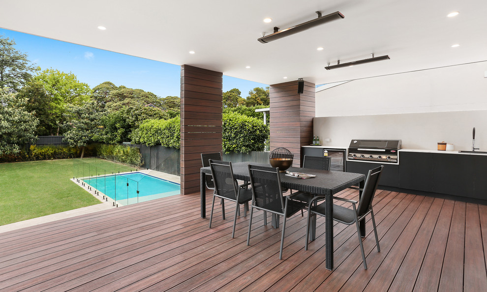 Design ideas for a mid-sized contemporary backyard deck in Sydney with an outdoor kitchen and a roof extension.
