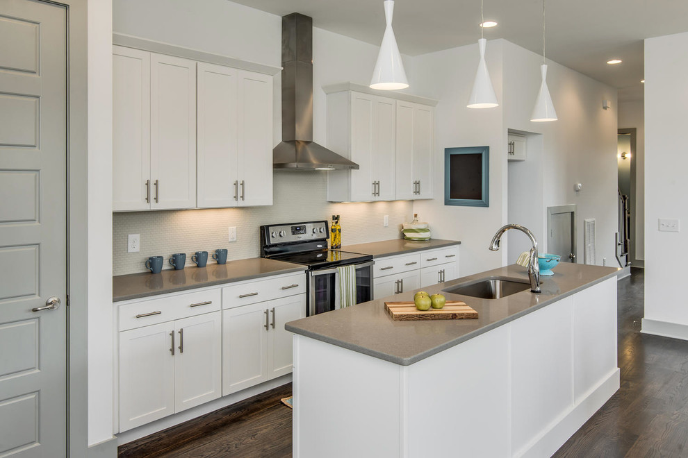 Design ideas for a small contemporary single-wall open plan kitchen in Nashville with an undermount sink, recessed-panel cabinets, white cabinets, quartz benchtops, white splashback, ceramic splashback, stainless steel appliances, dark hardwood floors and with island.