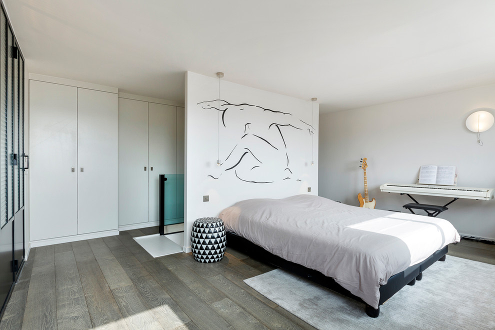 Large contemporary master bedroom in Paris with white walls, medium hardwood floors and grey floor.