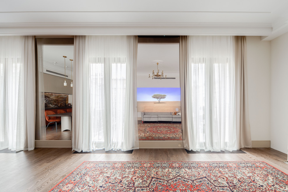 На фото: большая открытая гостиная комната в белых тонах с отделкой деревом в современном стиле с бежевыми стенами, паркетным полом среднего тона, скрытым телевизором и тюлем на окнах