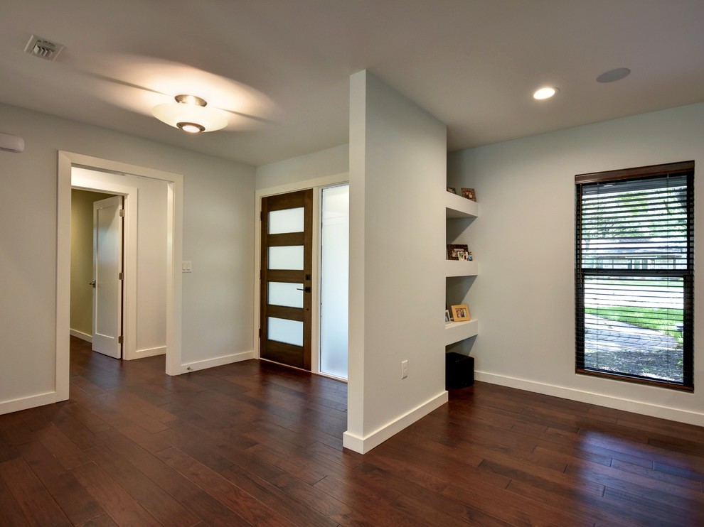 This is an example of a mid-sized contemporary front door in Austin with grey walls, dark hardwood floors, a single front door and a dark wood front door.