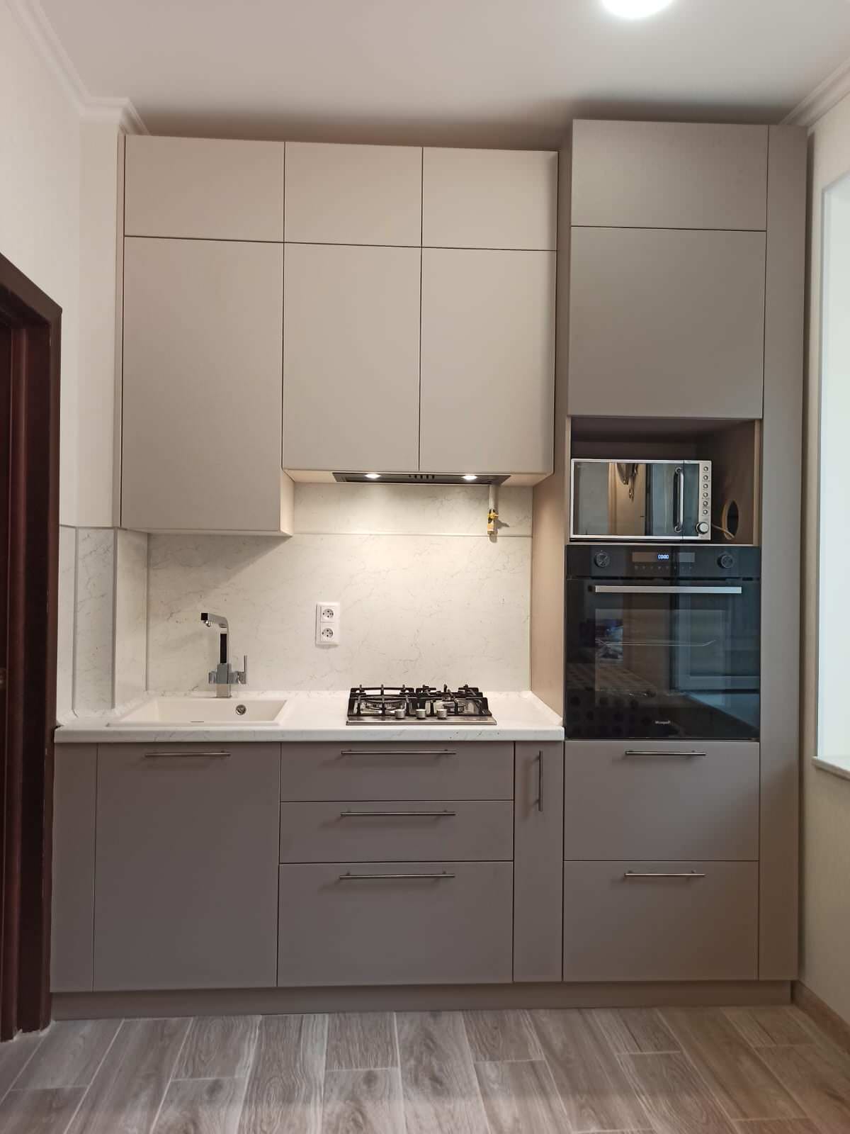 Небольшая кухня в бежевых тонах с комодом