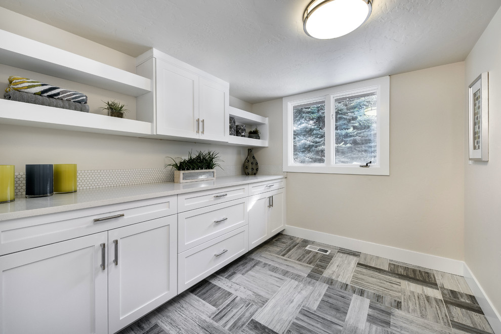 Mid-sized contemporary utility room in Boise with shaker cabinets, white cabinets, quartz benchtops, white walls, porcelain floors, a side-by-side washer and dryer and multi-coloured floor.
