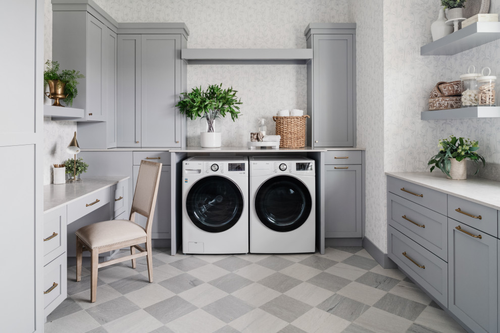 Diseño de lavadero en U tradicional renovado con armarios estilo shaker, puertas de armario grises, paredes blancas, suelo gris, encimeras blancas y papel pintado