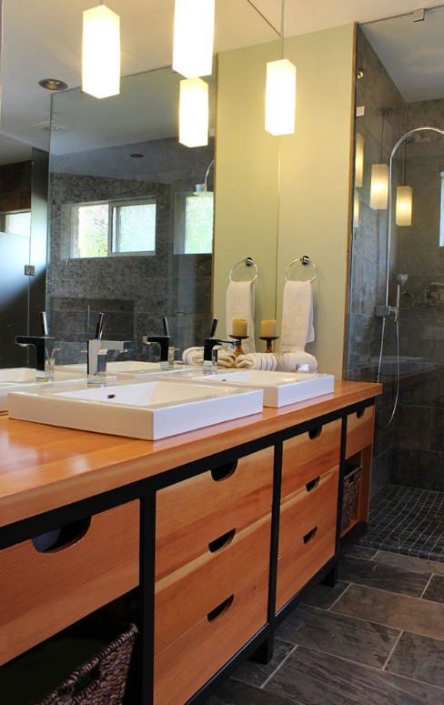 Inspiration for a mid-sized transitional master slate floor freestanding bathtub remodel with flat-panel cabinets, medium tone wood cabinets, a two-piece toilet, green walls, a drop-in sink and wood countertops