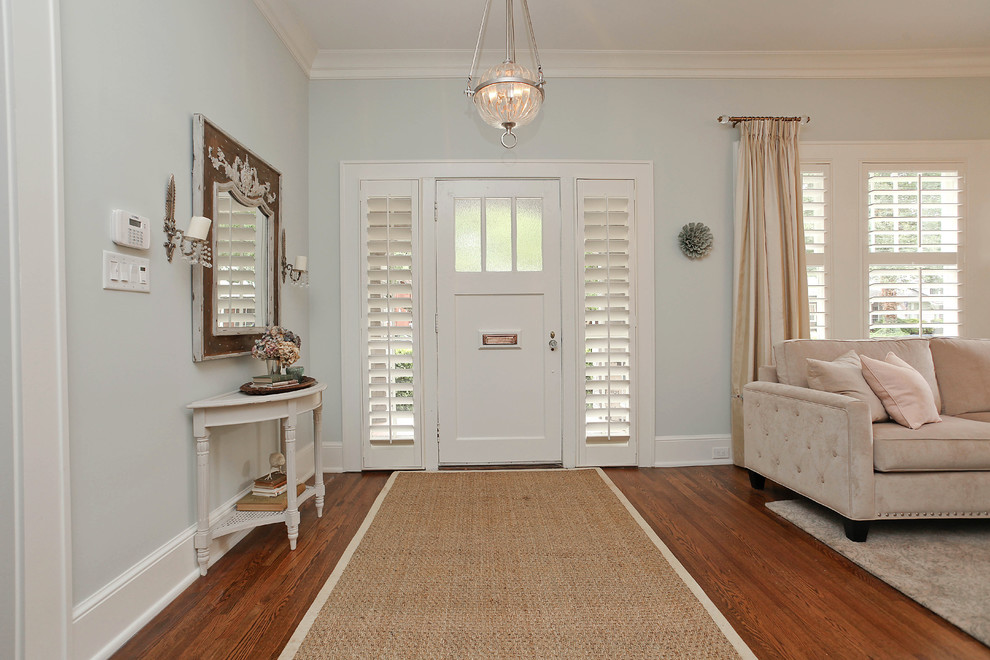Photo of an arts and crafts entryway in Charlotte with blue walls, medium hardwood floors and a white front door.