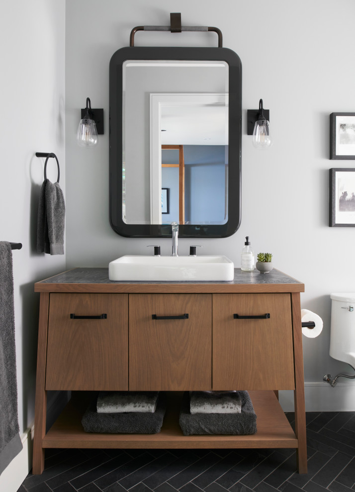 Imagen de cuarto de baño principal, único y de pie actual de tamaño medio con armarios con paneles lisos, puertas de armario de madera oscura, paredes grises, lavabo integrado, encimera de cuarcita y encimeras grises