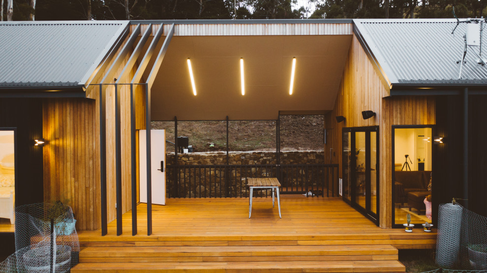 This is an example of a contemporary house exterior in Hobart with wood siding and a metal roof.