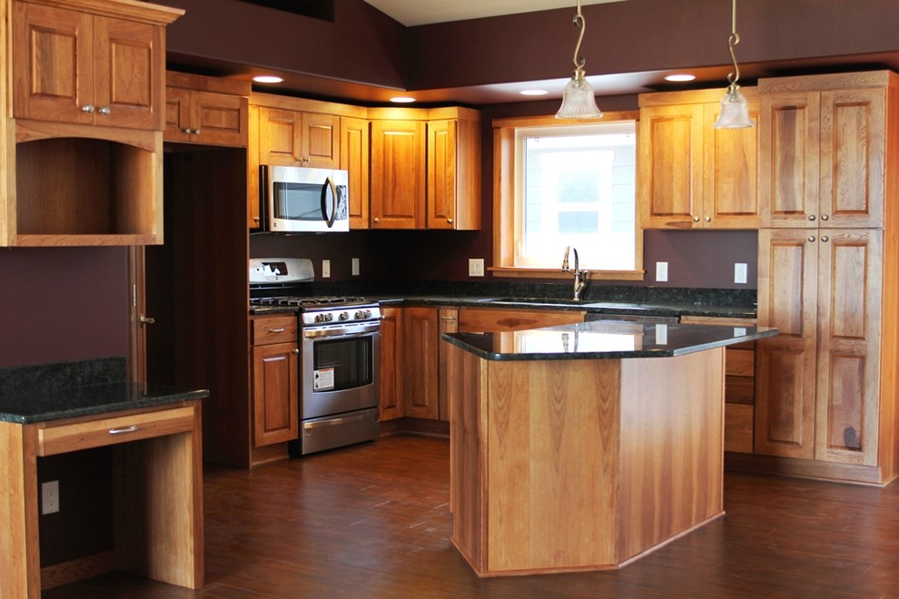 Example of a mid-sized transitional l-shaped medium tone wood floor eat-in kitchen design with an undermount sink, raised-panel cabinets, medium tone wood cabinets, granite countertops, stainless steel appliances and an island