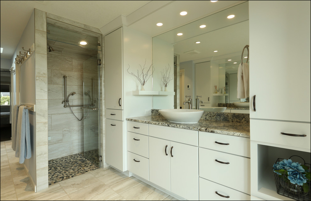 This is an example of a mid-sized transitional master bathroom in Portland with flat-panel cabinets, white cabinets, a curbless shower, beige tile, blue walls, ceramic floors, a vessel sink, granite benchtops, beige floor, a hinged shower door and beige benchtops.