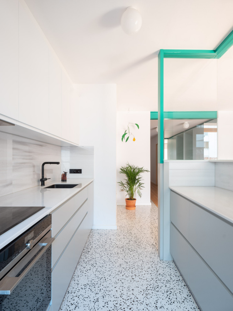 Design ideas for a small modern single-wall eat-in kitchen in Barcelona with an undermount sink, flat-panel cabinets, white cabinets, wood benchtops, white splashback, marble splashback, stainless steel appliances, terrazzo floors, white floor and white benchtop.