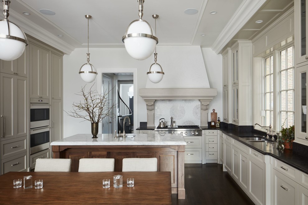 Design ideas for a large transitional u-shaped open plan kitchen in Chicago with an undermount sink, recessed-panel cabinets, beige cabinets, marble benchtops, white splashback, mosaic tile splashback, panelled appliances, dark hardwood floors and with island.
