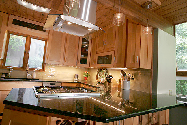 Eat-in kitchen - small transitional l-shaped porcelain tile eat-in kitchen idea with shaker cabinets, light wood cabinets, granite countertops, beige backsplash, glass tile backsplash, stainless steel appliances and a peninsula