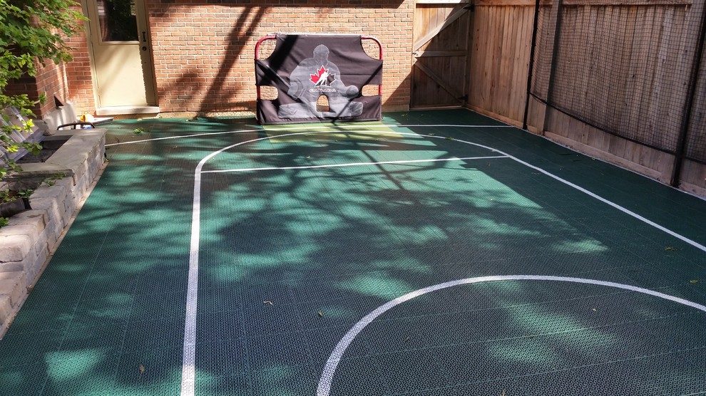 This is an example of a small modern backyard partial sun outdoor sport court for summer in Toronto with with outdoor playset and concrete pavers.