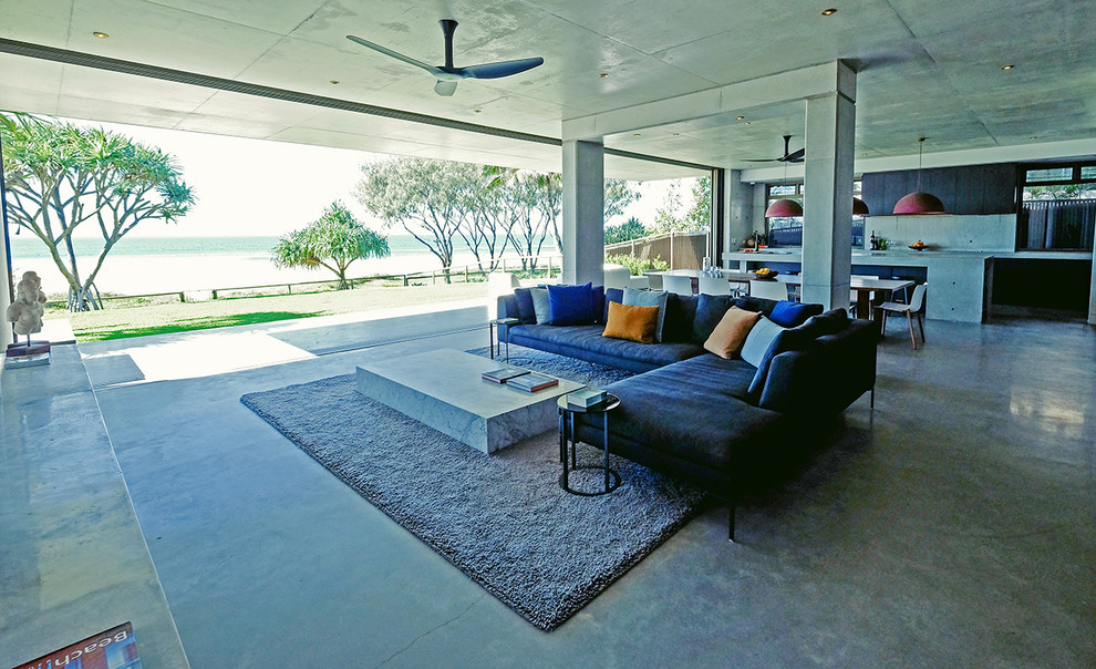 Large contemporary open concept living room in Brisbane with grey walls, concrete floors, a wall-mounted tv and grey floor.