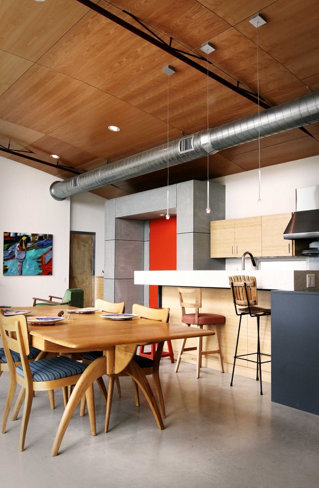 Industrial eat-in kitchen in Austin with flat-panel cabinets and light wood cabinets.