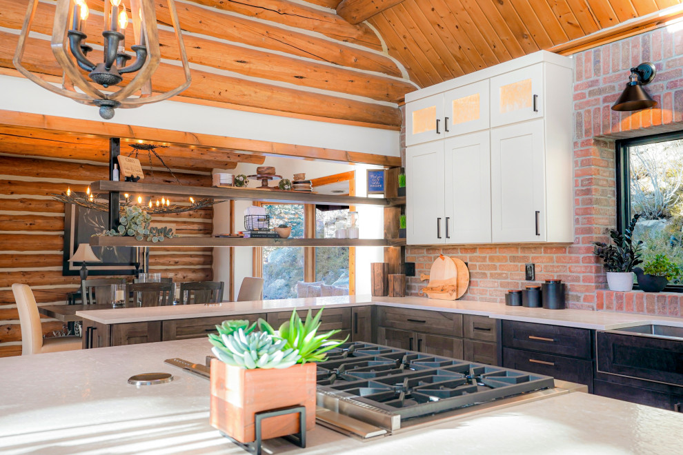 Photo of an expansive rustic u-shaped open plan kitchen with a belfast sink, shaker cabinets, dark wood cabinets, stainless steel appliances, an island and exposed beams.