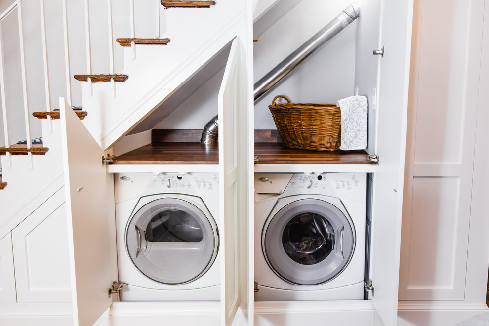 Design ideas for a small traditional laundry cupboard in Baltimore with shaker cabinets, white cabinets, wood benchtops, medium hardwood floors, a side-by-side washer and dryer, brown floor and brown benchtop.