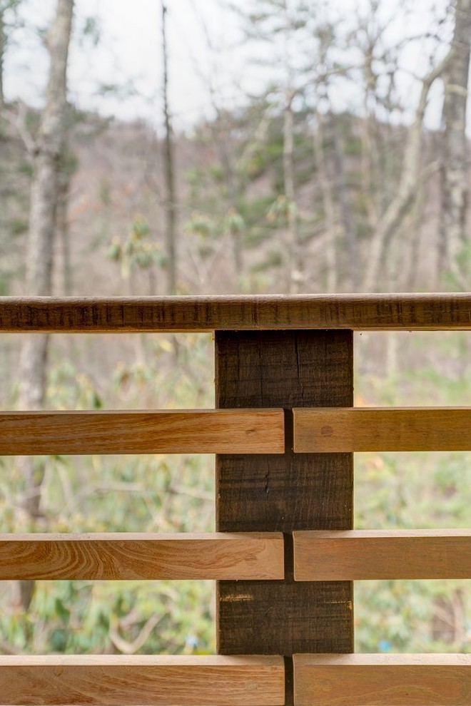 Mid-sized mountain style backyard deck photo with a roof extension