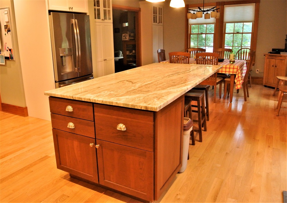 Inspiration for a transitional light wood floor kitchen remodel in Boston with an undermount sink, shaker cabinets, white cabinets, quartzite countertops, white backsplash, subway tile backsplash, stainless steel appliances and an island