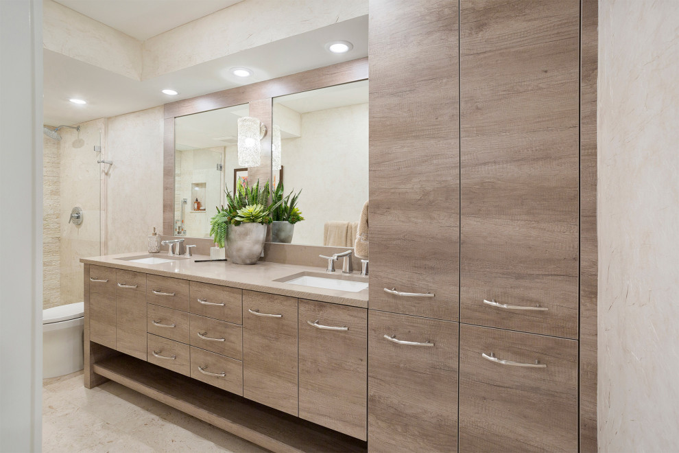 Inspiration for a mid-sized transitional master beige tile and stone slab ceramic tile and beige floor alcove shower remodel in Miami with flat-panel cabinets, brown cabinets, a one-piece toilet, beige walls, an undermount sink, solid surface countertops, a hinged shower door and beige countertops
