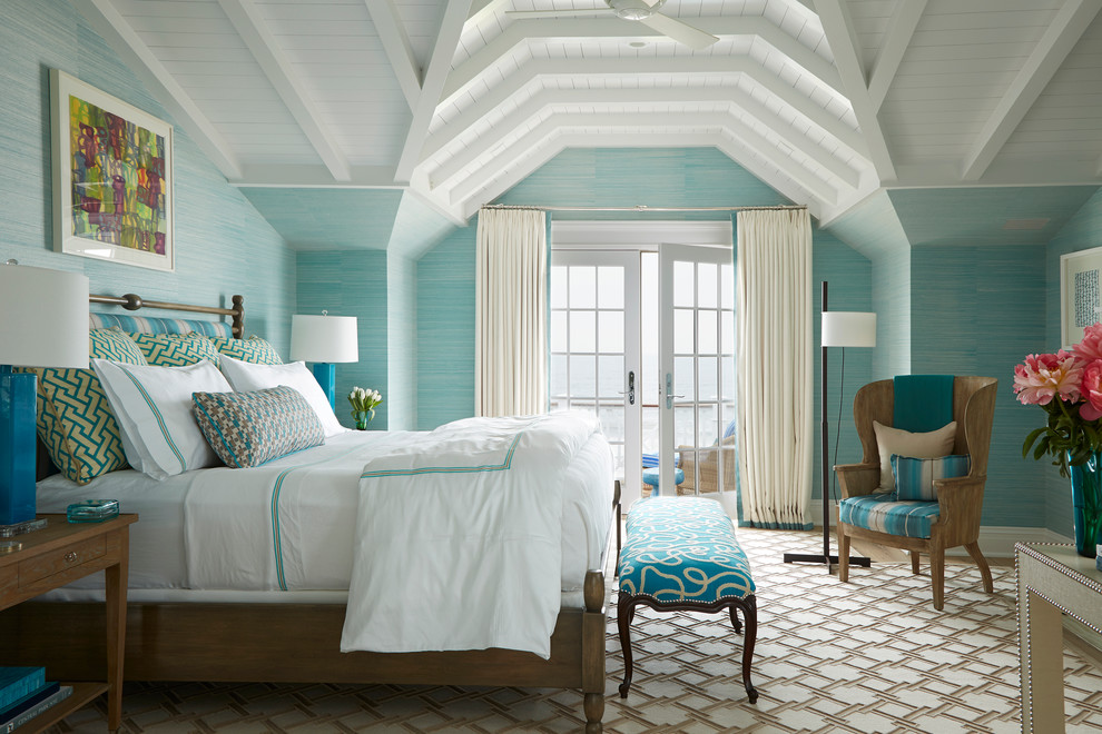 This is an example of a large beach style master bedroom in New York with blue walls, carpet and no fireplace.