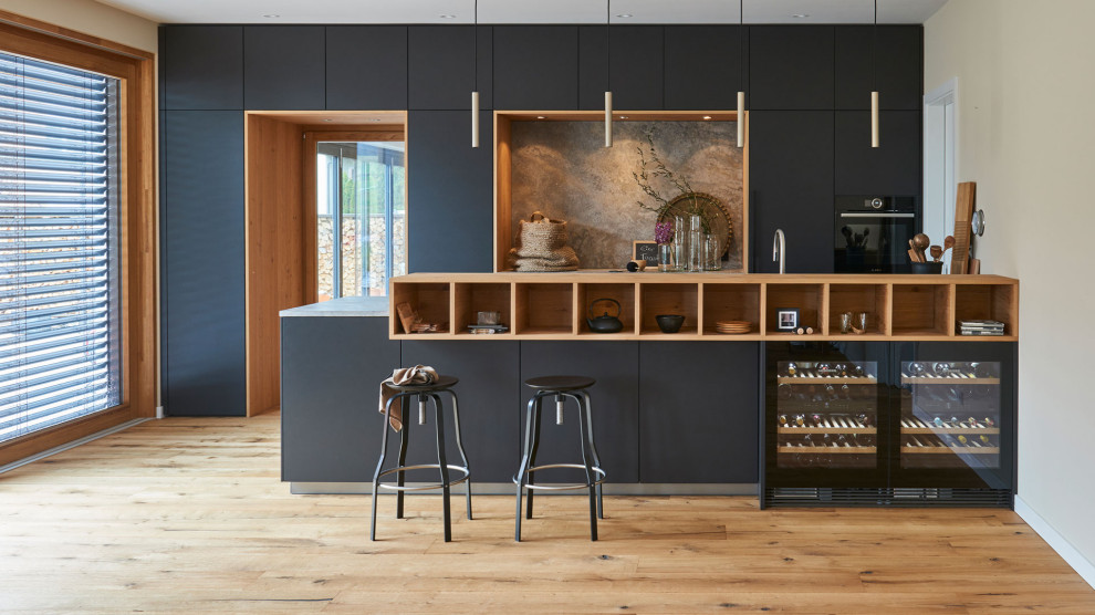 Inspiration for a contemporary kitchen in Munich with black cabinets, granite benchtops, with island and beige benchtop.