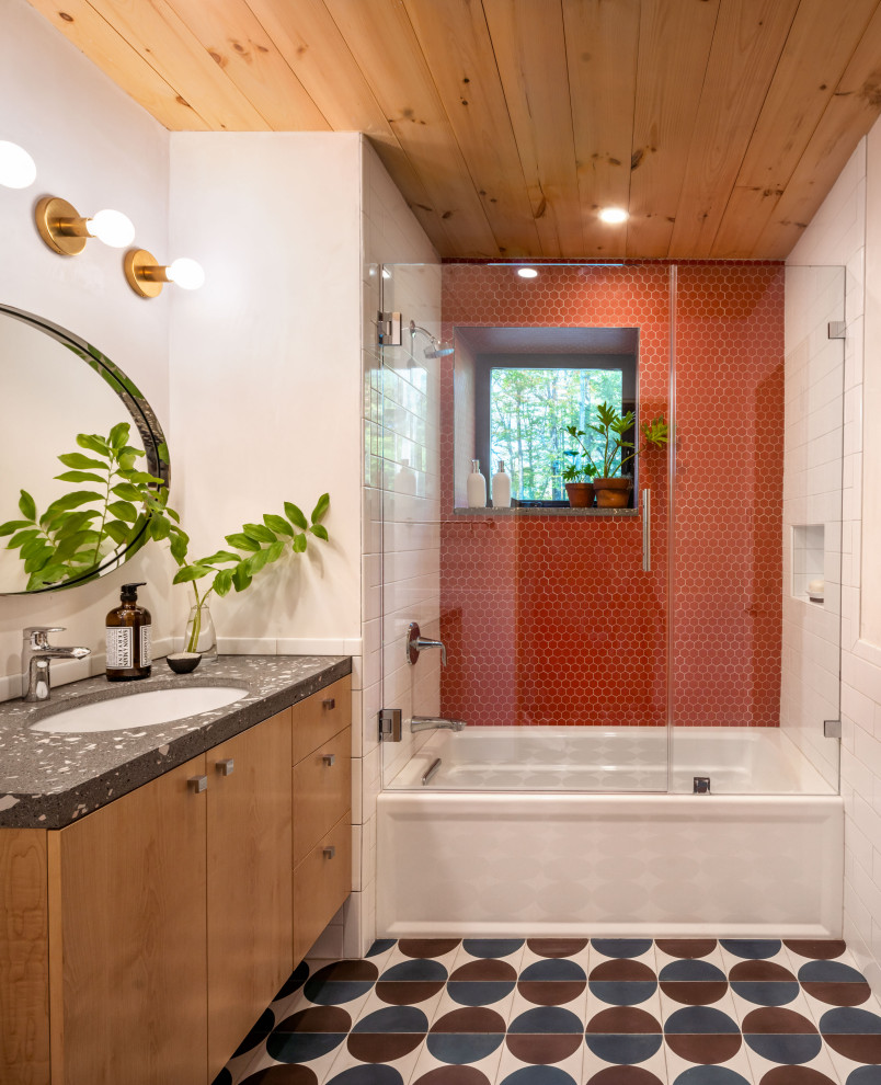 Inspiration for a medium sized contemporary bathroom in Boston with flat-panel cabinets, medium wood cabinets, an alcove bath, a shower/bath combination, red tiles, ceramic tiles, white walls, ceramic flooring, a submerged sink, multi-coloured floors, a hinged door, a single sink and a timber clad ceiling.