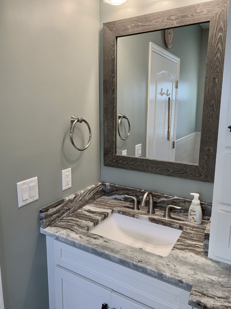 Mid-sized beach style master bathroom in Other with shaker cabinets, white cabinets, a drop-in tub, a corner shower, white tile, ceramic tile, blue walls, vinyl floors, an undermount sink, marble benchtops, grey floor, a hinged shower door and multi-coloured benchtops.