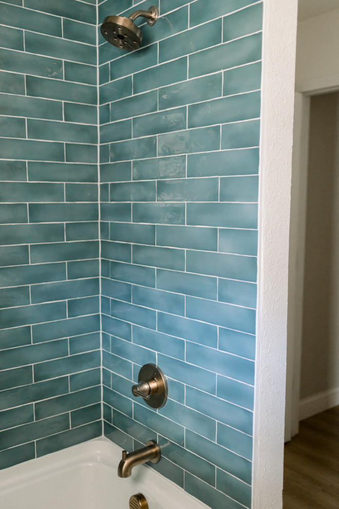 Idée de décoration pour une salle de bain design avec un combiné douche/baignoire, un carrelage bleu, des carreaux de céramique et un mur marron.