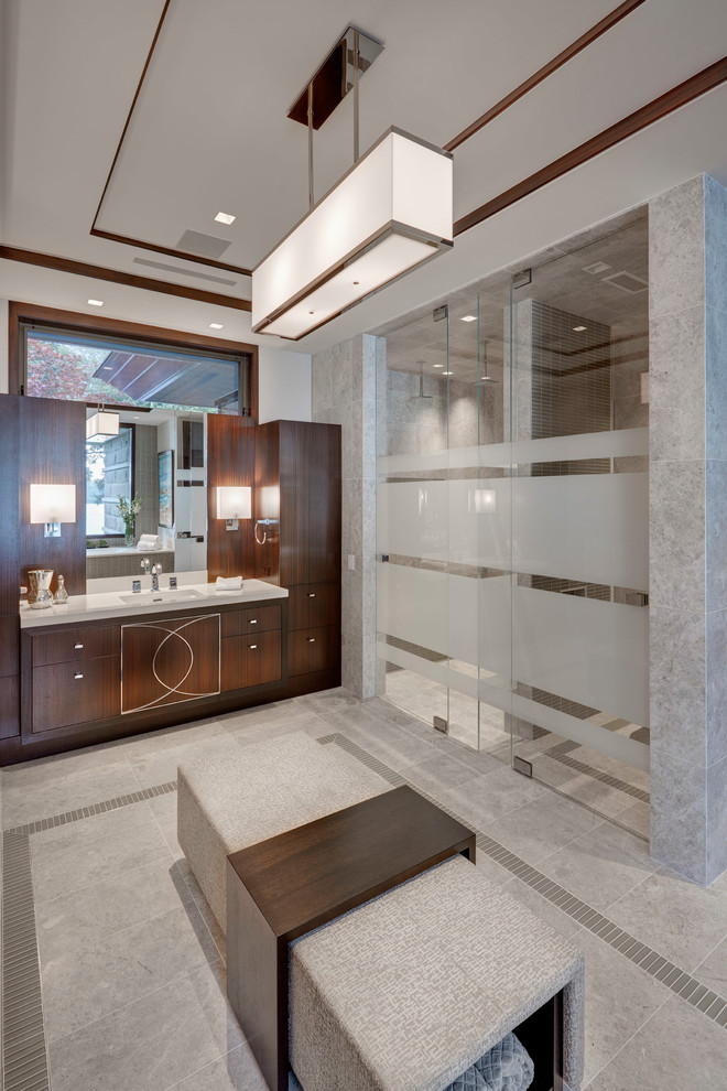 This is an example of a contemporary bathroom in Detroit with flat-panel cabinets, dark wood cabinets, an alcove shower, white walls, grey floor and white benchtops.