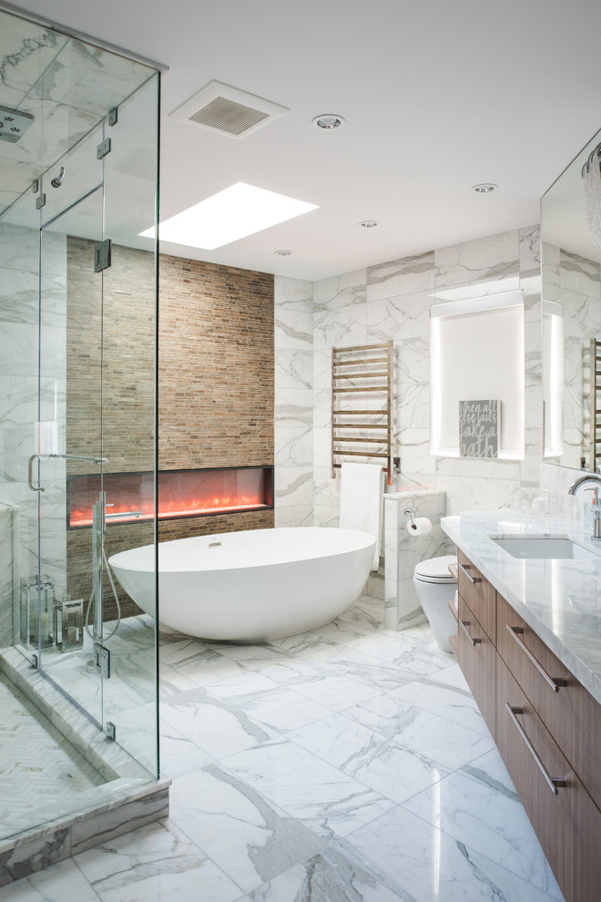 Design ideas for a large contemporary master bathroom in Vancouver with flat-panel cabinets, medium wood cabinets, a freestanding tub, white tile, an undermount sink, white floor, a corner shower, a one-piece toilet, marble, white walls, marble floors, marble benchtops, a hinged shower door and white benchtops.