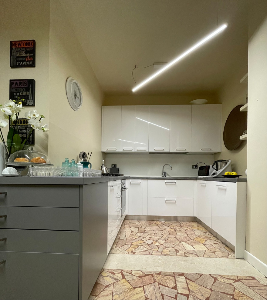 Photo of a mid-sized contemporary u-shaped separate kitchen in Other with flat-panel cabinets, white cabinets, laminate benchtops, terrazzo floors, beige floor and grey benchtop.